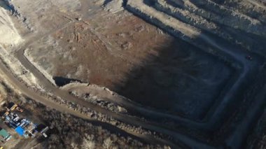 Granit ocağı. Granit taş madenciliği. Taş ocağının yüksekliğinden manzara. Bir kazıcı kamyonu taşla dolduruyor..
