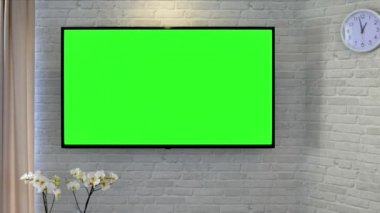 Elinde uzaktan kumandayla televizyon izliyorsun. Oturma odasındaki tuğla duvara karşı yeşil ekran televizyon. Kanal değiştir ve rahatlamak için evde otur..