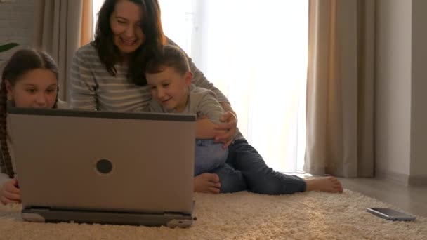 家族は親戚とインターネットを介してオンラインで通信します ラップトップでビデオチャットで話している子供たちとお母さん リモート通信 — ストック動画