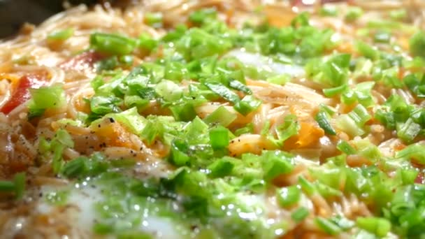 Cocinar la cena en una sartén. Cazuela de pasta. Macarrones con cebolla verde y queso . — Vídeos de Stock