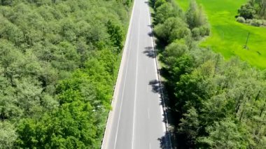 Arabasız boş bir yol. Otoyol, geçen arabalar olmadan tarlalardan ve ormanlardan geçiyor.. 