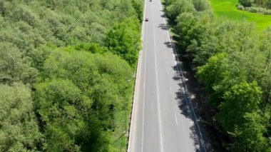 Arabalı yol. Otoyol geçen arabalarla tarlalardan ve ormanlardan geçiyor. 