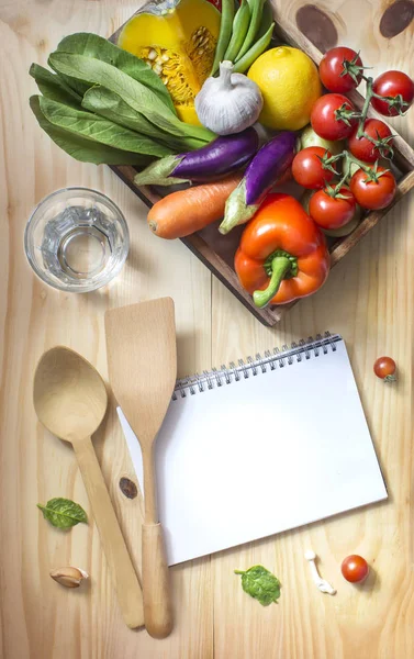 Verduras en caja con cuaderno en blanco y agua —  Fotos de Stock