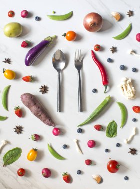 çatal bıçak takımı ve çilek beyaz yüzeyi sebzeler ile