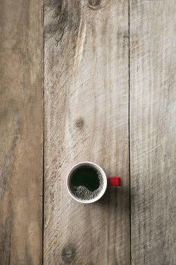 Kavramsal düz siyah kahve Kupası görüntüde yatıyordu. Ahşap arka plan.