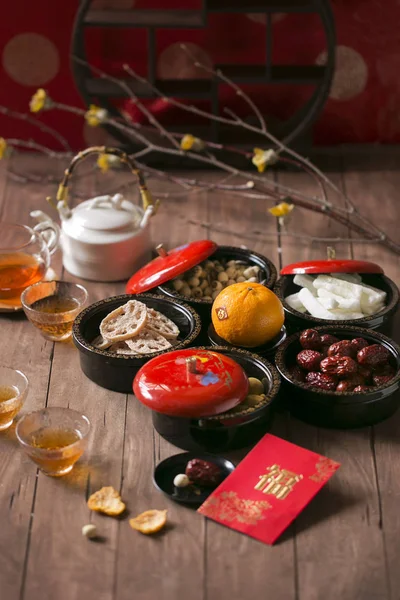 Chinese new year food and drink and decoration items on wooden table top. Text appear in image: Prosperity.