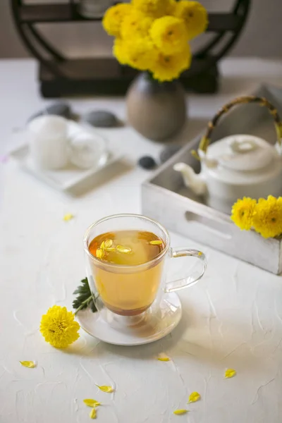 Öğleden sonra Chrysanthemum çayı ile snack üzerinde beyaz masa üstü.
