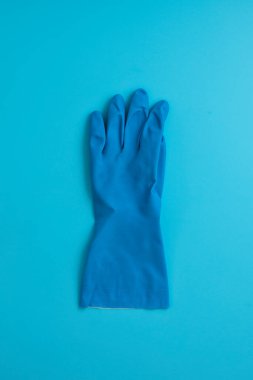 Mavi arka planda temizlik, temizlik, yıkama, bahçe işleri için koruyucu mavi eldiven.