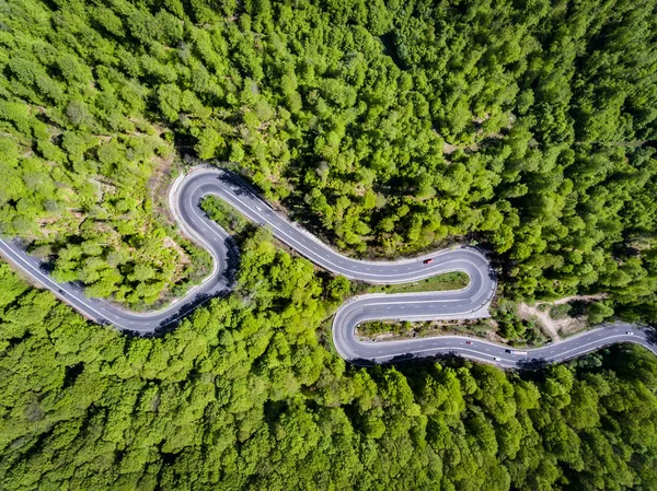 森の中の曲がりくねった道。ルーマニア ・ トランシルバニアのヨーロッパ。車 — ストック写真