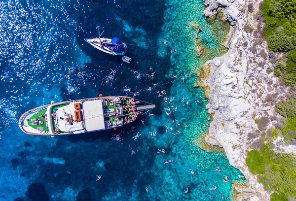 Menschen, die im klaren blauen Wasser der Insel Antipaxos schwimmen, — Stockfoto