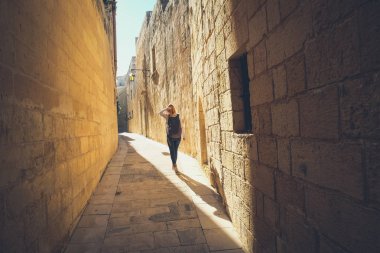 Eski Mdina dar sokaklarında. Yürüyen turist. Tipik archit