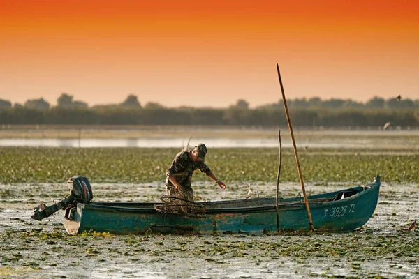 Danube Delta, August 2017: Fisherman catching fish at sunrise in