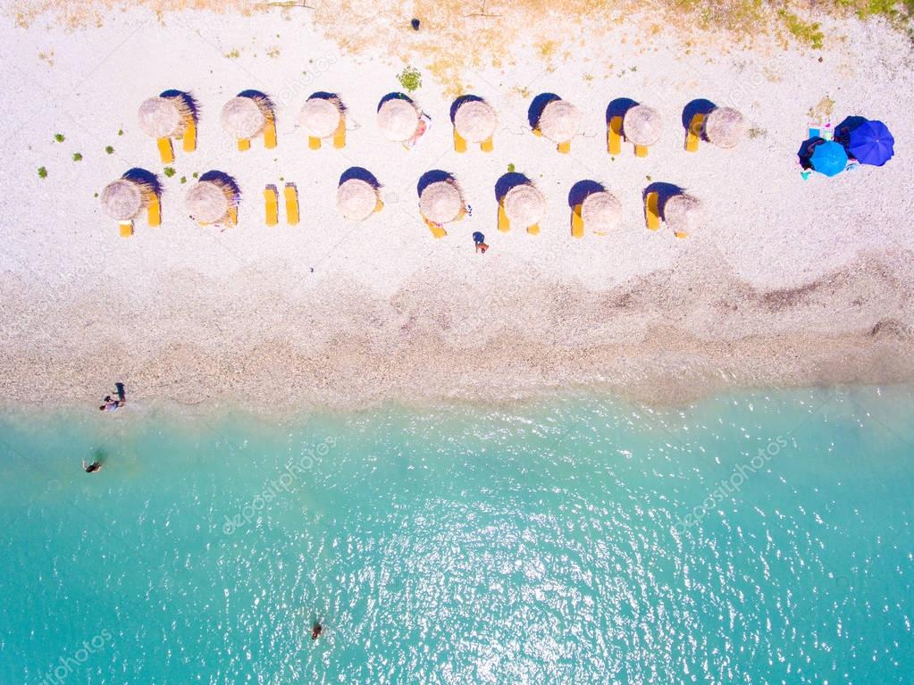 Summer beach in Lefkada Greece with sun umbrellas and sunbeds an