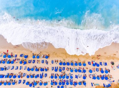 Kuşbakışı bir Beach büyük dalgalar, şezlong ve şemsiye ile