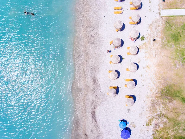 Piaszczystej plaży w Grecji ptaka z parasolami i leżakami — Zdjęcie stockowe