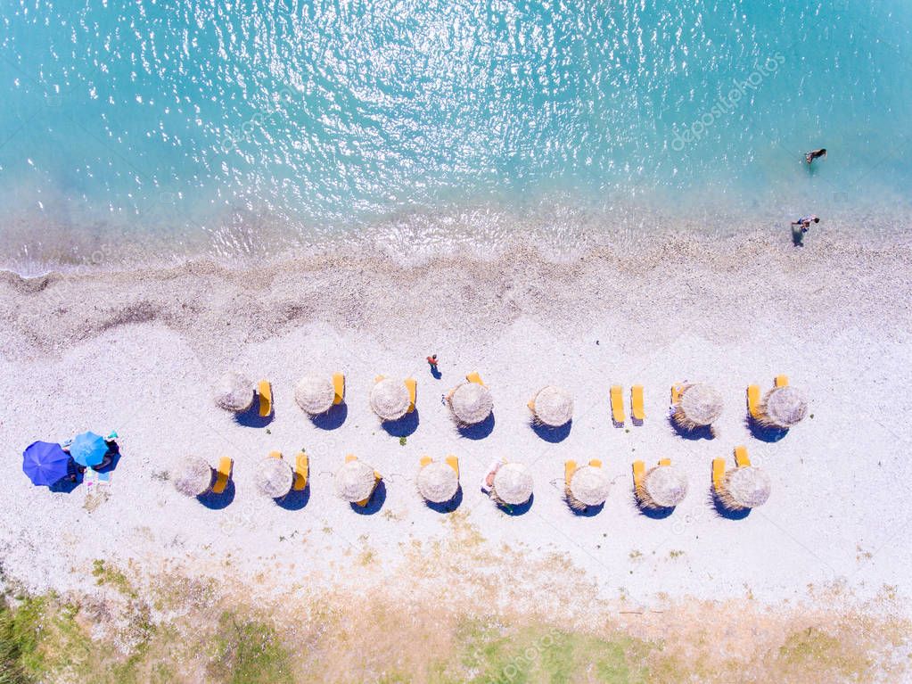 Sand beach in Greece aerial view with umbrellas and sunbeds 