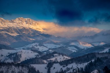 Kışın gün batımında, şiddetli havada Karpat Dağları
