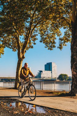 Köln, Almanya - Eylül 2018: Köln, Almanya 'da sabahın erken saatlerinde bisiklet süren turist