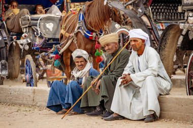 Edfu, Egypt - Jan 2019:  People of Egypt, old Egyptians waiting to transport tourists in carriages at Edfou Temple, Behdet clipart