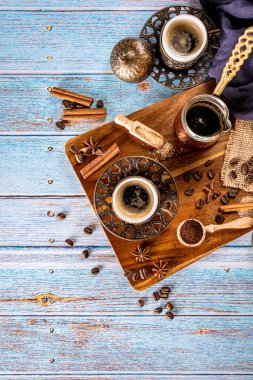 Kahve fincanlarıyla mavi arkaplan, kahve çekirdekleri, kahve fincanı ve kahve demliği, fotokopi alanı ile retro tarzı, üst görünüm