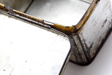 Beyaz bir arka plan üzerinde paslı metal bir kutu