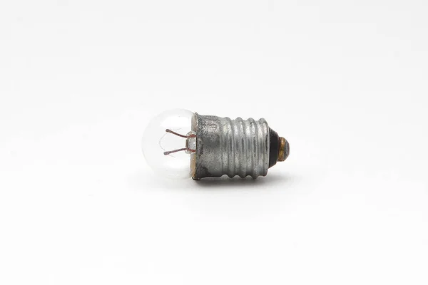 Une petite lampe à incandescence sur fond blanc — Photo