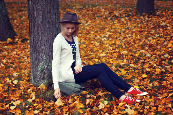 Walk in the autumn park. The girl has a rest. The photo is tinte