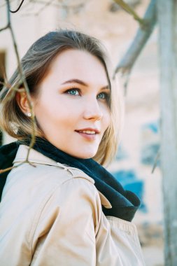 Şehvetli mavi gözlü kız bulanık arka planda şakayla poz veriyor.