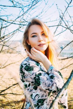 Şehvetli mavi gözlü kız bulanık arka planda şakayla poz veriyor.