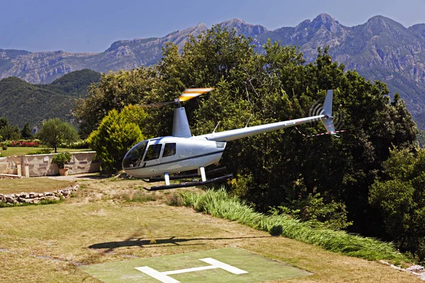 Um helicóptero voador em um belo jardim de um hotel de luxo na Itália — Fotografia de Stock