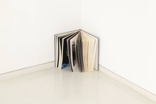 Otevřená kniha na rohu místnosti jako abstraktní instalace — Stock fotografie