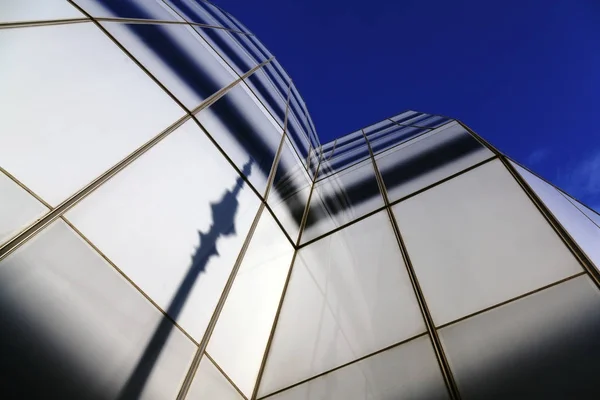 Reflection of a street pole on a glass building