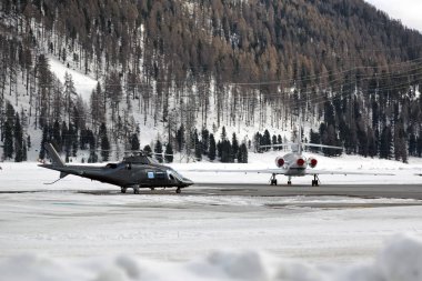 Bir helikopter ve karlı manzara ve alps İsviçre dağlarında bir özel jet