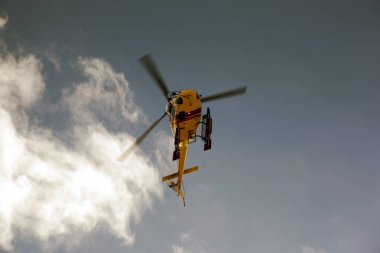 Mavi gökyüzünde uçan bir helikopter