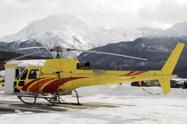 Kışın karlı alps İsviçre sarı bir helikopter
