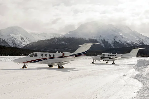 Two private jets in the snow covered airport of St Moritz in the alps switzerland in winter