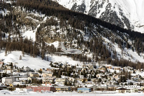 A private jet landing to St Moritz airport in snowy mountains in the alps switzerland