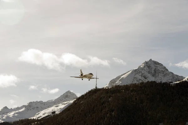 A private jet landing to St Moritz airport in snowy mountains in the alps switzerland