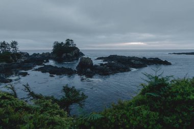 Adalar, uçurumlar ve bulutlar ile uzak kıyı görünümü