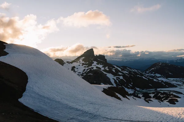 Nuvoloso tramonto lunatico sulle montagne innevate sopra il Lago Garibaldi sul Pa — Foto Stock