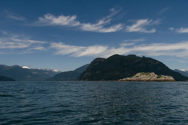 Kayaker solitario sull'acqua con montagne sullo sfondo — Foto Stock