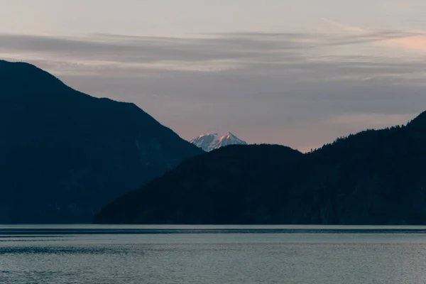 Linea costiera la sera con la montagna che brilla sullo sfondo — Foto Stock