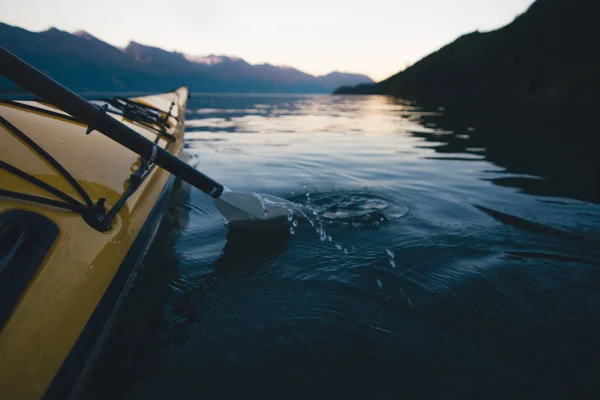 独自在平静的水面上划独木舟, 背景是山 — 图库照片
