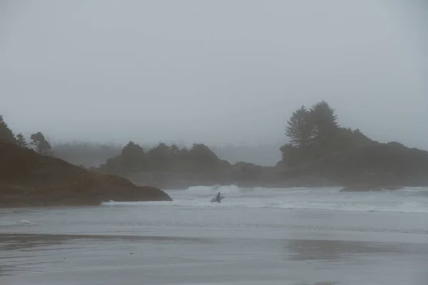 Surfista andando na praia no nevoeiro — Fotografia de Stock