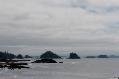 Adalar, uçurumlar ve bulutlar ile uzak kıyı görünümü