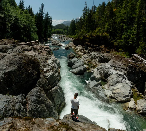 Чоловік стоїть на скелі над річкою — стокове фото