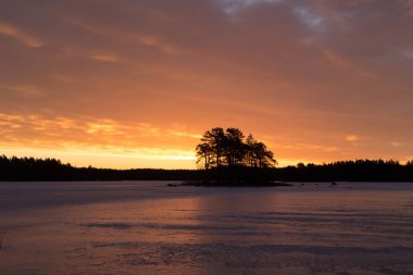 Bulutlar gökyüzünde ve donmuş göl ile renkli gündoğumu