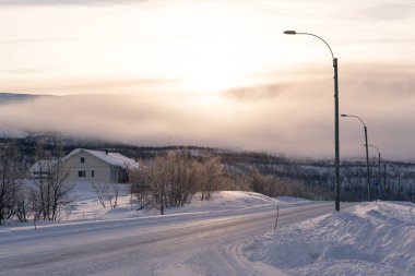 Evin önünde içinde ülke donmuş ile dağın arkasında gündoğumu