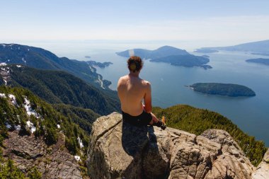 Adalar manzaralı cliff bay yukarıda üzerinde oturan adam