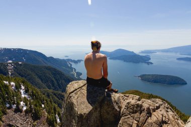 Adalar manzaralı cliff bay yukarıda üzerinde oturan adam